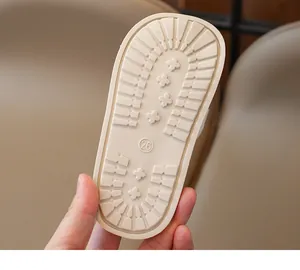 Detail of toddler slipper rubber sole featuring anti-slip cross patterns in beige