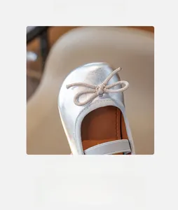 Close-up of silver metallic girl's Mary Jane shoe with a dainty bow and round toe design