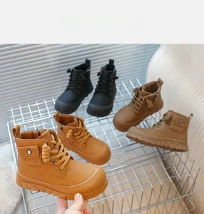 Détail de bottes pour enfants en cuir avec poches latérales et fermeture éclair en noir et brun