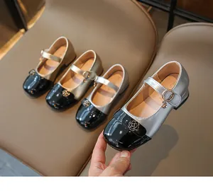 Dettaglio di scarpe Mary Jane per bambina con fibbia a camelia e pelle verniciata lucida