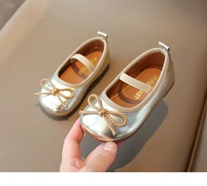 Close-up of golden Mary Jane shoes for girls featuring a woven bow and metallic finish