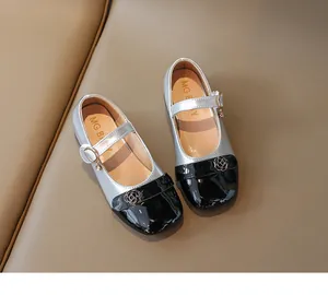 Dettaglio di scarpe Mary Jane per bambina con finitura argento e fibbia a rosa nera