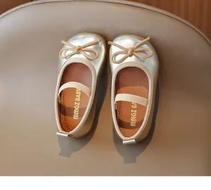 Detailed top view of gold Mary Jane shoes with khaki bow and soft elastic strap