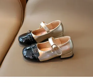 Dettaglio scarpe Mary Jane bimba nero e oro con fibbia a rosa e ciondolo dorato