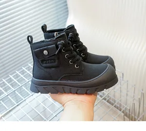 Gros plan de bottes noires pour enfants avec texture cuir et poche latérale décorative