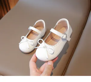 Primer plano de zapato Mary Jane de charol blanco con lazo y hebilla de corazón
