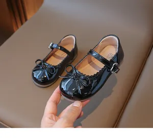 Detalle de zapatos Mary Jane de charol negro con lazo y hebilla de corazón