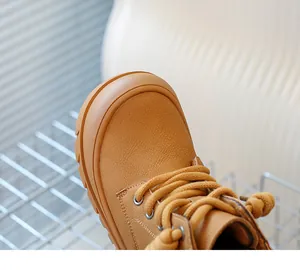 Détail de la texture du cuir marron et des coutures de ces bottines enfant