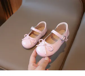 Detalle de lazo rosa y hebilla de corazón en zapatos Mary Jane de charol para niñas