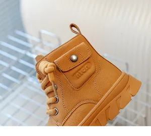 Détail d'une botte pour enfant en cuir camel avec lacets tissés et poche latérale