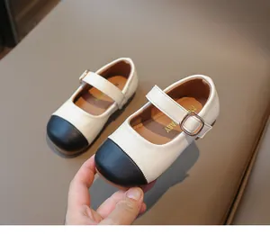 Detailed close-up of girls color-block Mary Jane shoes with gold metallic buckle