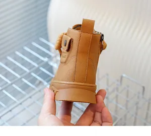 Détail de bottines camel pour enfants avec finition texturée et fermeture zippée