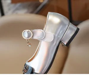 Dettaglio scarpa principessa argento bambina con ciondolo strass e decorazione rosa
