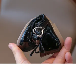 Vista detallada de la flexibilidad de los zapatos de charol negro para niñas con hebilla