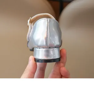 Vista dettagliata del tallone in vernice metallizzata argento e cuciture su scarpe Mary Jane