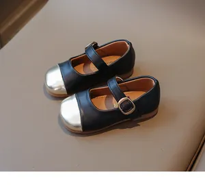 Close-up of girls' black and gold Mary Jane shoes with metallic toe and strap detail