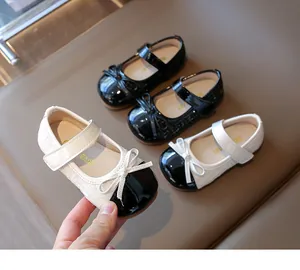 Close-up of girls' Mary Jane shoes with tweed bow detail and polished patent leather finish