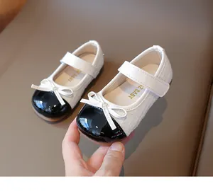 Close-up of girls' Mary Jane shoes featuring black patent leather and white tweed texture