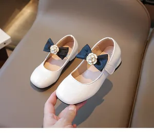 Detail weißer Lackleder Mary Jane Schuhe für Mädchen mit Kamelie und schwarzer Schleife