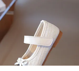 Detail of girls' white tweed Mary Jane shoe with bow accent and leather strap