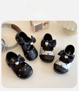 Détail de chaussures Mary Jane pour enfants avec motif matelassé, nœud et perle en cœur