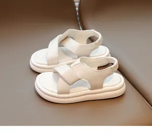 Dettaglio di sandali bianchi per bambini con ampie fasce incrociate e tallone elastico