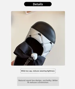 Détail de chaussure argentée pour enfant avec nœud noir, motif cœur et perle