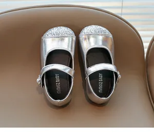 Detailed view of silver Mary Jane girl's shoes with shimmering sequins and pearl buckle