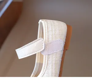 Detail of white tweed fabric and velcro strap on girl's Mary Jane princess shoe