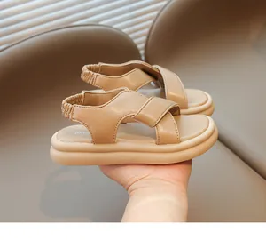 Dettaglio di sandali platform per bambini con cinturini beige incrociati e cinturino elastico