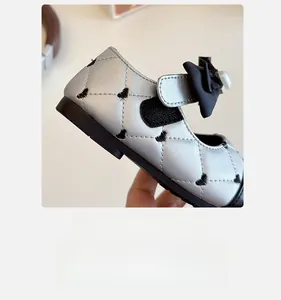 Détail de chaussure Mary Jane argentée avec broderie cœur, nœud et fermeture velcro