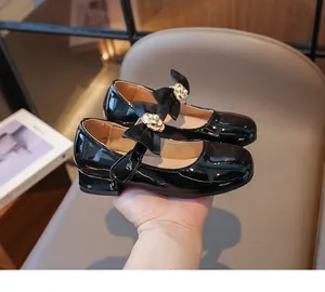 Detail von Mädchen Mary Janes aus Lackleder mit großer Satinschleife und Perlenblume