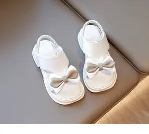 Detail von weißen Mädchensandalen mit großer Schleife und elastischem Fersenriemen