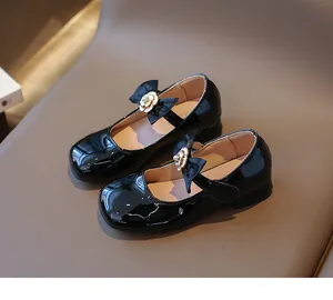 Detail von schwarzen Lackleder-Mary-Janes für Mädchen mit Kamelien- und Schleifendekor