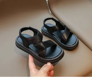 Dettaglio di sandali neri per bambini con cinturini incrociati e suola morbida antiscivolo
