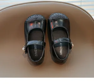 Detail of girls' black patent Mary Jane shoes with glitter toe and pearl flower buckle