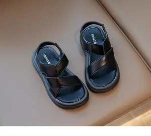 Dettaglio di sandali neri per bambini con cinturini incrociati ed elastico tallone