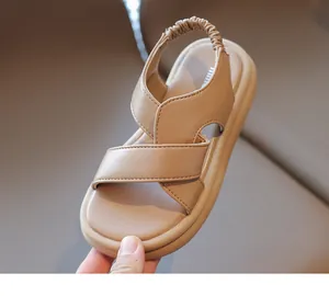 Dettaglio di sandali beige per bambini con cinturini incrociati e fascia elastica