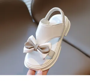 Detailansicht weißer Mädchensandalen mit großer Schleife und elastischem Fersenband