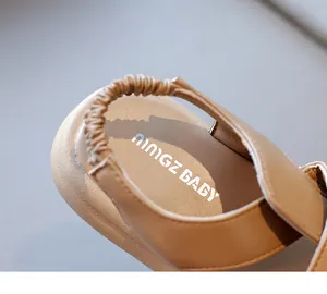 Dettaglio di sandali in camoscio marrone con cinturino elastico e cuciture premium