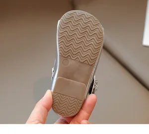 Detail of non-slip wavy texture sole on silver girls' shoes with size 23 embossing