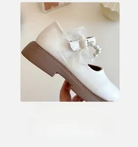 Detail of girls Mary Jane shoe with silk bow pearl strap and velcro closure