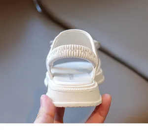 Nahaufnahme weißer Mädchensandalen mit elastischem Fersenriemen und dicker Gummisohle