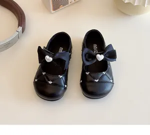 Vue de dessus de babies noires pour filles avec nœud, perle de cœur et broderie matelassée