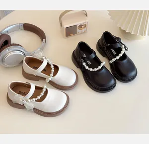 Detailed top view of black and white Mary Jane shoes with pearl lace bows and soft soles