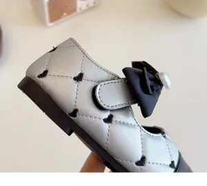 Détails des chaussures argentées pour bébés avec broderies de cœurs et nœud perlé