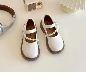 Detail of cream Mary Jane shoe for girls with pearl strap and white mesh bow decoration