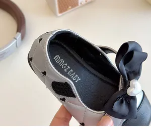 Détail de chaussures bébé matelassées argentées avec broderie cœur et boucle en perle