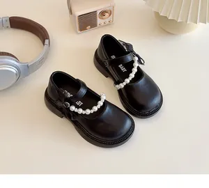 Detail of girls' black Mary Janes featuring pearl strap and bow on vintage background