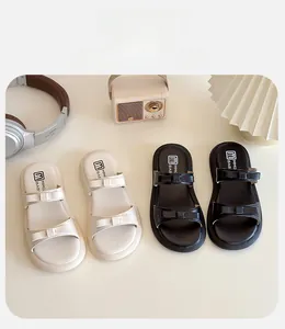 Close-up of children's bow-knot sandals in black and cream with soft leather straps